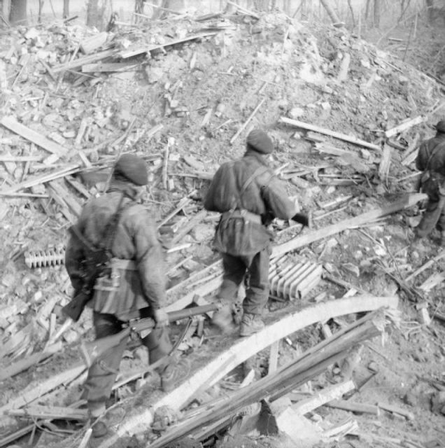 The British Army in North-west Europe 1944-45. Assault on the Rhine and Capture of Wesel. Commandos make their way over a bomb crater.