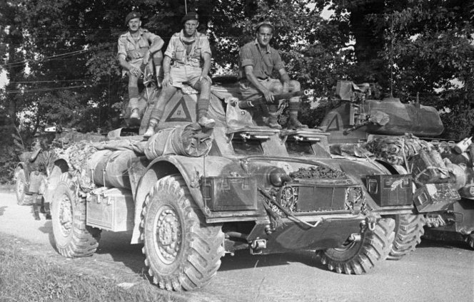 WWII soldiers of the 2nd New Zealand Divisional Cavalry Battalion on a Staghound armored car.