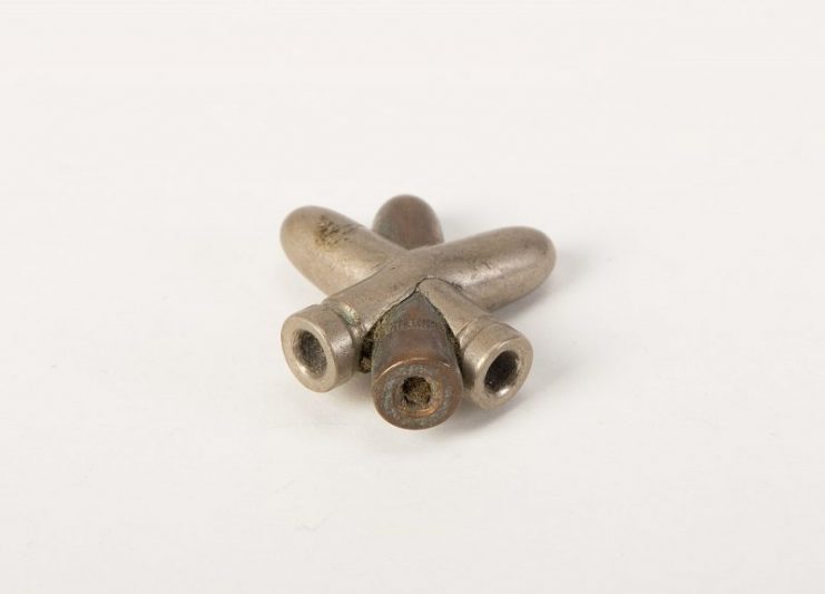 Trench art (ornament) of three crossed bullets (WW1) three crossed bullets, possibly part of a larger object. Photo: Auckland Museum / CC BY 4.0