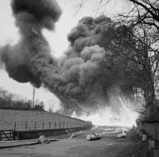 A flame barrage demonstration staged by the Petroleum Warfare Department at Mid Calder in Scotland, 28 November 1940. Barrels of petrol were projected using a ‘hedge hopper’ device and ignited electrically, and were intended for use against enemy tanks and vehicles.