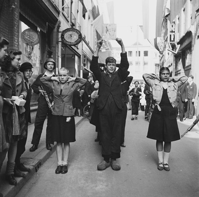 Members of the NSB (Dutch national socialist party) and shaven ‘kraut girls’ are being brought in by members of the Dutch Resistance.