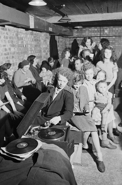 A young woman plays a gramophone in an air raid shelter in north London during 1940.