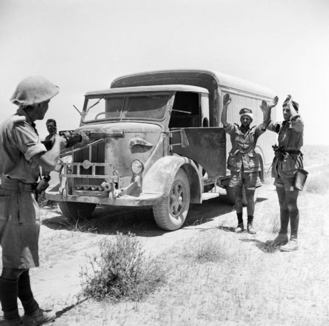 A British infantryman takes the surrender of the crew of an enemy supply truck in the Western Desert, 2 June 1942.