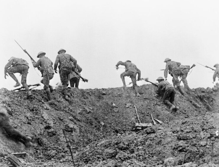 British soldiers climbing over the top of a trench