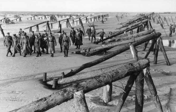 France,Belgium – Field Marshal Erwin Rommel with officers on inspection of wooden barriers on the beach before the Atlantic Wall, April 1944.