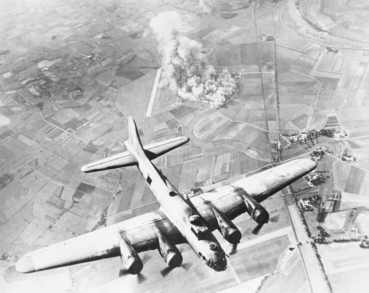 Boeing B-17 Flying Fortress flying over a Focke-Wulf factory