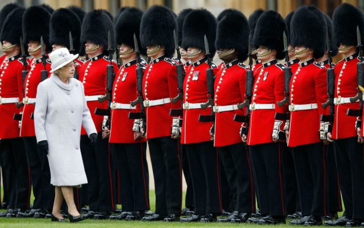 Queen Elizabeth II walking toward a line of guardsmen from 1st Battalion and No. 7 Company of the Coldstream Guards