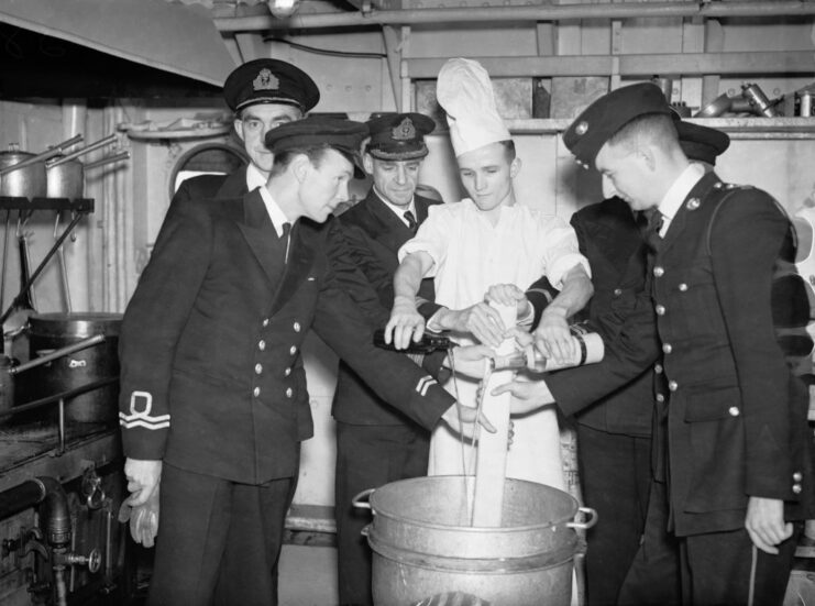 British Royal Navy sailors standing around a large metal vat