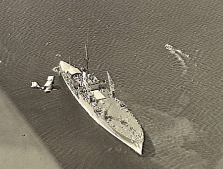 The Australian seaplane tender HMAS Albatross with one of her aircraft overhead