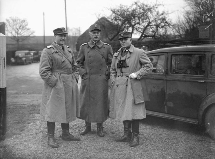 HRH Crown Prince Olaf of Norway and the Commander in Chief Home Forces, at large scale exercises in England – wearing trench coats.