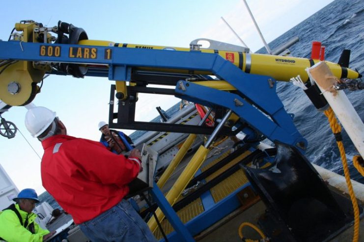 Naval Oceanographic Office surveyors John Suslavage and David Small prepare to launch autonomous underwater vehicle, REMUS 600 aboard the Military Sealift Command oceanographic survey ship USNS Henson (T-AGS 63). (U.S. Navy photo by Rebecca Burke/Released)