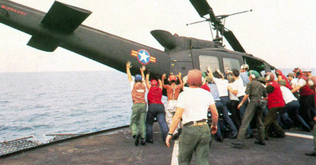 South Vietnamese UH-1H being pushed overboard to make room for a Cessna O-1 landing. 