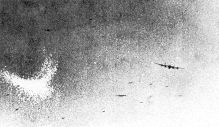 An Avro Lancaster dropping Window (the crescent-shaped white cloud on the left of the picture) from within the accompanying bomber stream.