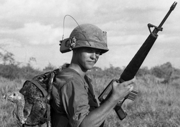The turkey that found its way by helicopter to the 9th Infantry Division was destined for the nearby Bear Cat base camp. It was one of 57,000 sent in to provide as many as possible of the half-million Americans in Vietnam with the traditional holiday feast. Note Radio in Helmet band.