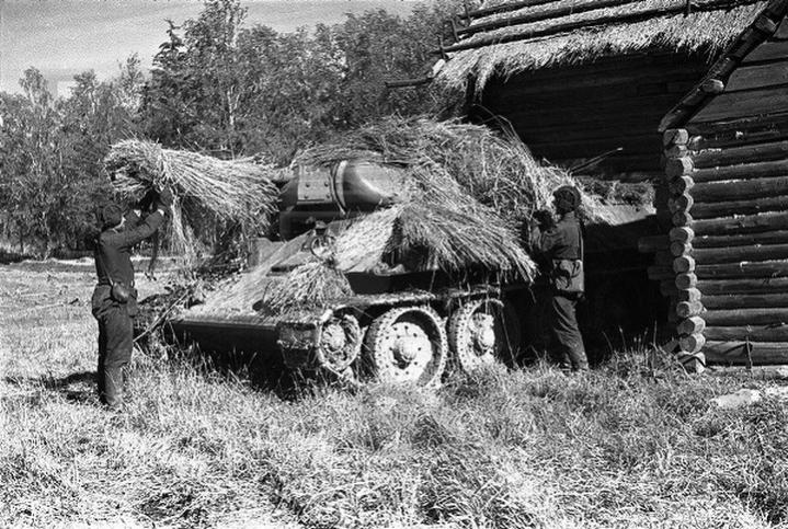 Concealed force- members of 122nd Tank Brigade camouflage their T-34 tank for the Siege of Leningrad, 1941