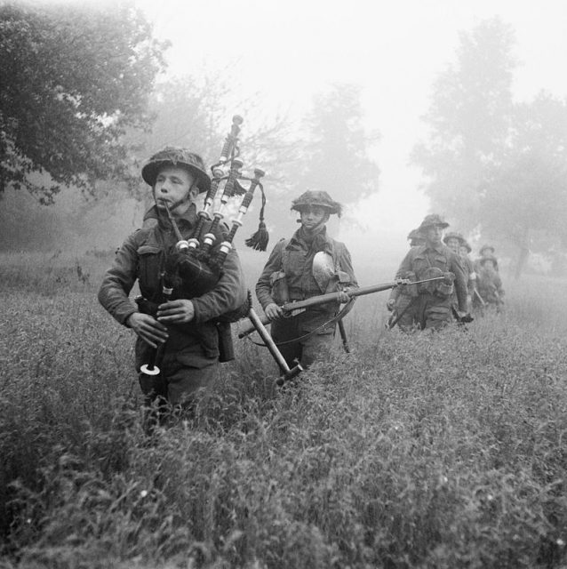 Led by their piper, men of the 7th Seaforth Highlanders, 15th (Scottish) Division advance during a battle.