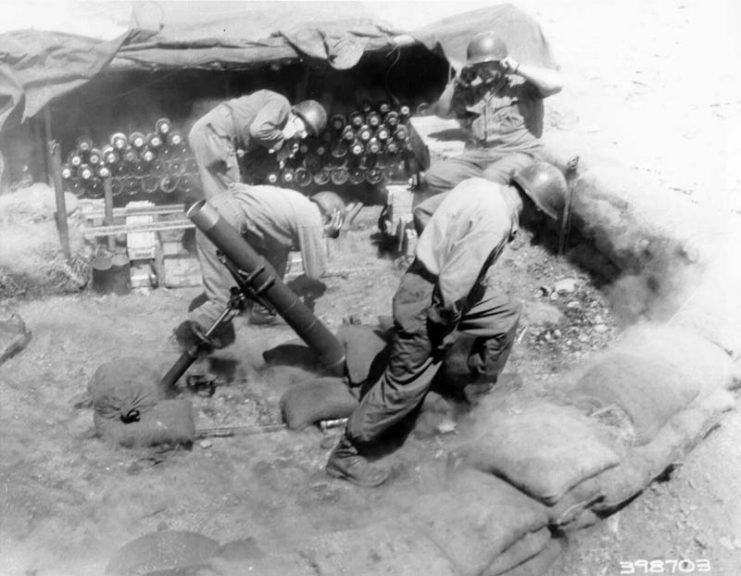 A 4.2-inch mortar crew, 45th U.S. Infantry Division, fires on Communist positions, Korea.