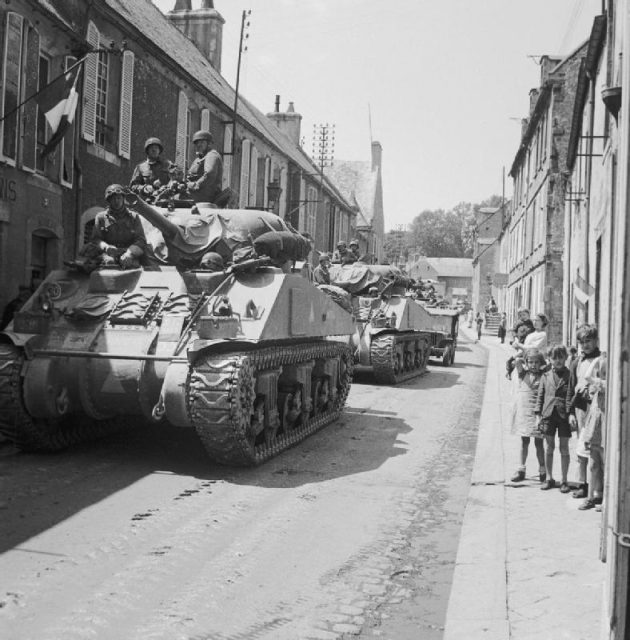 Sherman tanks of British 30th Corps passing through Bayeux, liberated by the British 50th Infantry.