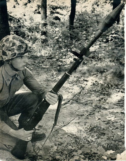 U.S. Marine preparing to fire M31 HEAT antitank rifle grenade from M1 rifle in the indirect mode with butt on the ground.1950s