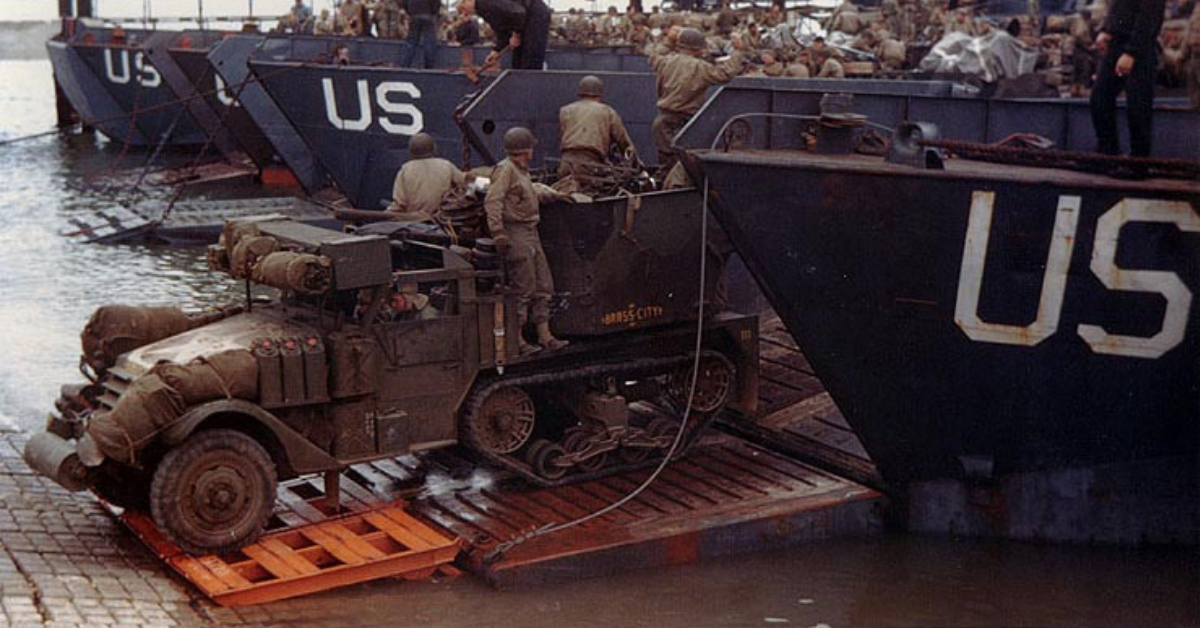 A US Army half-track antiaircraft machine gun vehicle backed into the well deck of a US Navy LCT in preparation for the Normandy invasion, late May or early June 1944