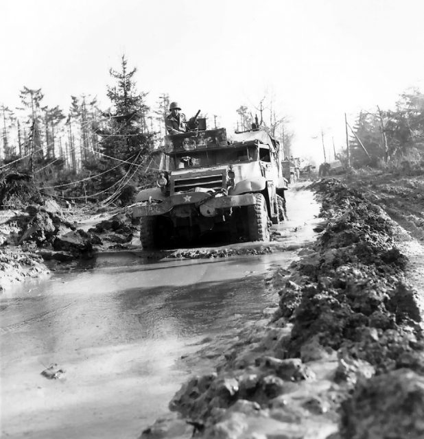 M3 Half-track vehicle of 16th Infantry Regiment, US 1st Infantry Division moving through a muddy road in the Hürtgen Forest, Germany, 15 February 1945.