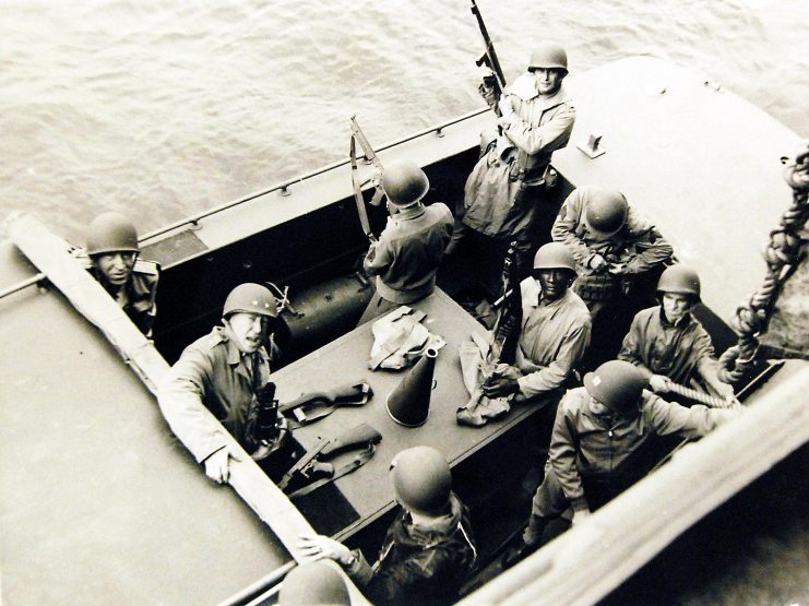 Operation Torch, November 1942. Going Ashore. Major General George S. Patton, Jr., USA, shouts a few last minute instructions before going ashore in North Africa with Rear Admiral John L. Hall, Jr., USN, standing behind him. Note the convenient “Tommy Gun.” U.S. Navy Photograph, released December 21, 1942.