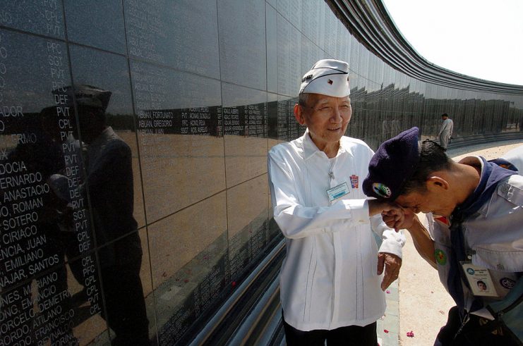 CAPAS, PHILIPPINES: An unidentified Boy Scout kisses the hands of Filipino World War II veteran Rafael Estrada, 87, in a gesture of respect, at the Capas National Shrine in northern Tarlac province, 06 April 2004 during a memorial day marking the fall of Bataan. 