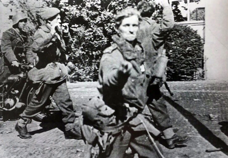 Lt. Jack Reynolds (aged 22) was famously photographed after being taken prisoner during the Battle of Arnhem. In the photo, he is seen giving the “two-fingered” salute to the German photographer.