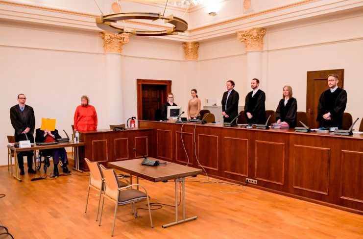 Former SS guard Bruno Dey (2nd L) covers his face as he waits at the courtroom for the start of a session of his trial in Hamburg. GETTY