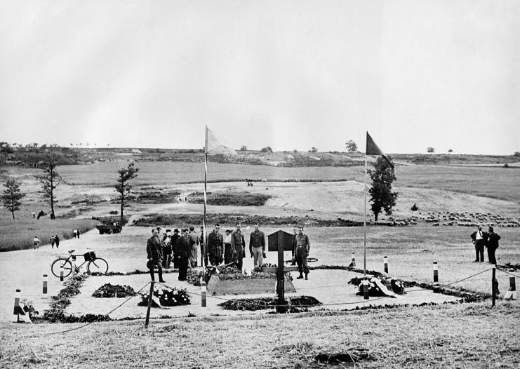 American soldiers at the mass grave of the residents of Lidice (Central Bohemia), who had been killed by the SS and police officers in retaliation for the attempt to assassinate Reich Protector Reinhard Heydrich on June 10, 1942 ; the fields in the background cover the rubble of the village, which was razed to the ground. GETTY