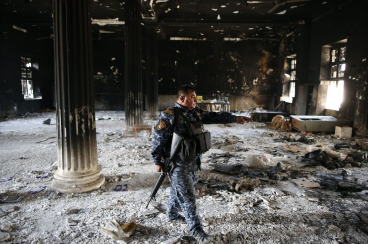 A member of the Iraqi forces inspects the damage inside the destroyed museum of Mosul on April 2, 2017 after they recaptured it from Islamic State (IS) group fighters.