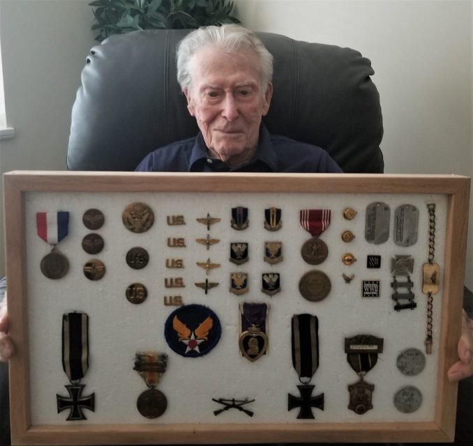 Lon Douglas enlisted in the U.S. Army Air Forces in WWII and trained as a navigator aboard a transport plane used to search for enemy submarines in the Gulf of Mexico. He is holding a display case with some of his military medals and those of his father, a WWI combat veteran. Courtesy of Jeremy P. Amick