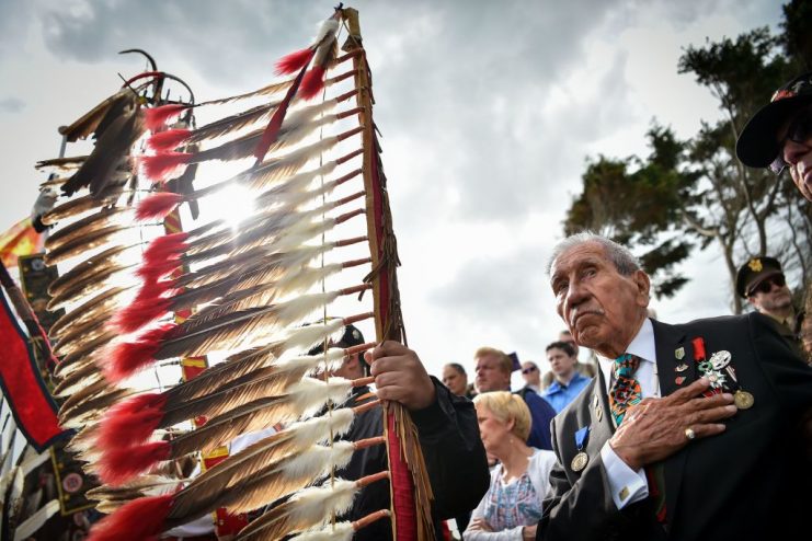 WWII US native American Indian veteran Charles Shay listens to the national anthem as he takes part in a ceremony on Omaha Beach. LOIC VENANCE/AFP via Getty Images