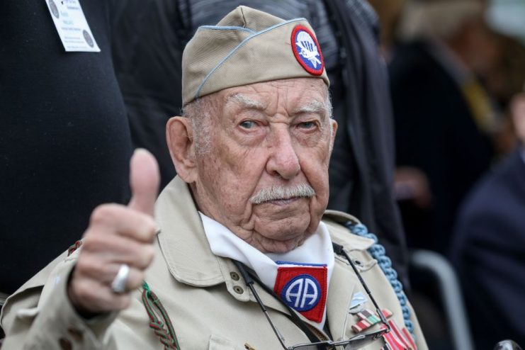 US veteran Raymond Wallace gestures as he arrives to take part in the “Carre de Choux” commerative ceremony, in Carentan.  LUDOVIC MARIN/AFP via Getty Images