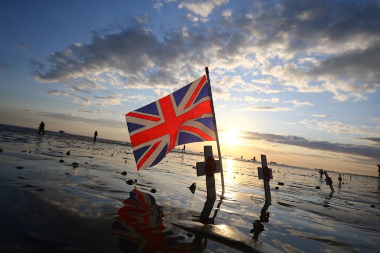 Crosses of remembrance placed alongside a Union flag at dawn on the beach at Arromanches in Normandy. Gareth Fuller/PA Images via Getty Images