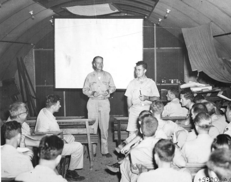 At a mission briefing, then Captain William Parsons (1901 – 1953) (standing, left) and then Colonel Paul Tibbets (1915  2007) (standing, right) go over last-minute data with prior to the atomic bombing of Hiroshima, Tinian airbase, North Marianas Islands, August 5, 1945. (Photo by PhotoQuest/Getty Images)