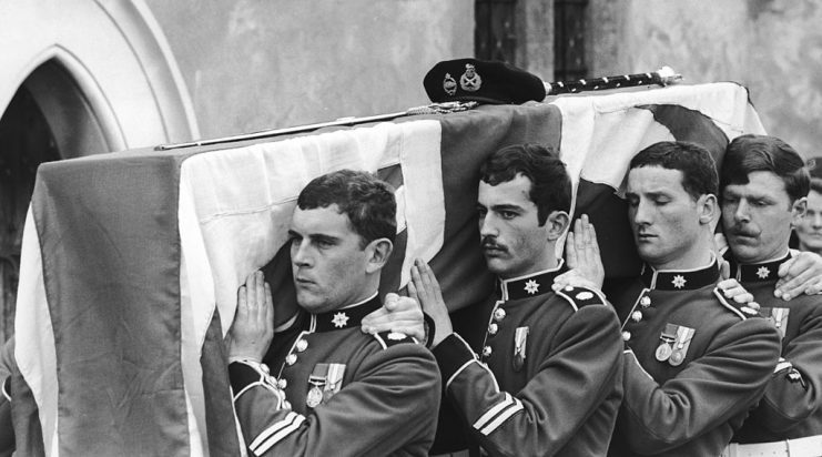 The funeral of Field Marshal Bernard Law Montgomery, 1st Viscount of Alamein (1887 – 1976) at the Church of the Holy Cross in Binsted, Hampshire, 1st April 1976. Members of the 2nd Battalion Coldstream Guards carry the coffin through the churchyard to its final resting place under a 50-year-old yew tree. (Photo by David Ashdown/Keystone/Hulton Archive/Getty Images)