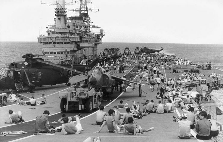 Staff on board HMS Hermes sunbathing on the flight deck as the naval task force heads for the Falkland Islands following the Argentinian invastion, April 1982. (Photo by Martin Cleaver/Pool/Getty Images)