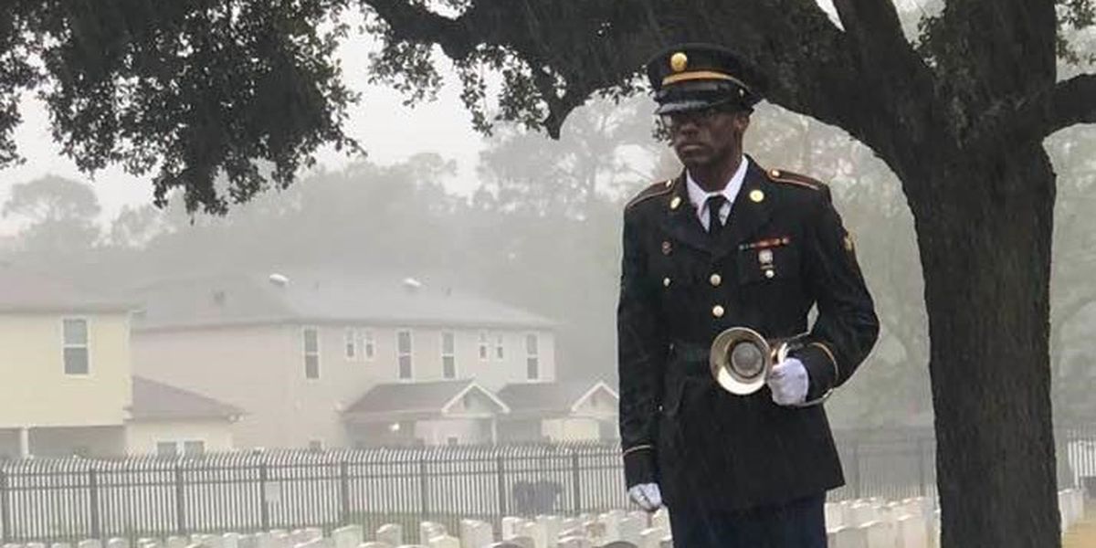 A photo of a soldier standing in the pouring rain playing TAPS at the funeral of a South Mississippi veteran is going viral. (Source: Kim Wiley)