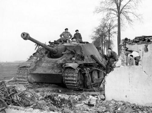 Soldiers of the Polish 1st Armoured Division pose with a destroyed German jagdpanther heavy tank destroyer at Hechtel. The commander of the Schwere Panzerjäger Abteiling 559, Major Erich Sattler, was driving his jagdpanther to Hechtel when a British Cromwell tank ambushed it. After surviving a hit from the larger German vehicle, the Cromwell was able to outmaneuver his opponent and knock it out by firing four rounds at close range into its engine. Allied troops salvaged this Sattler’s vehicle, which is displayed in the Imperial War Museum London.