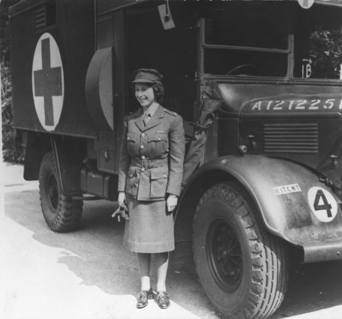 Queen Elizabeth II standing beside a first aid truck while in uniform