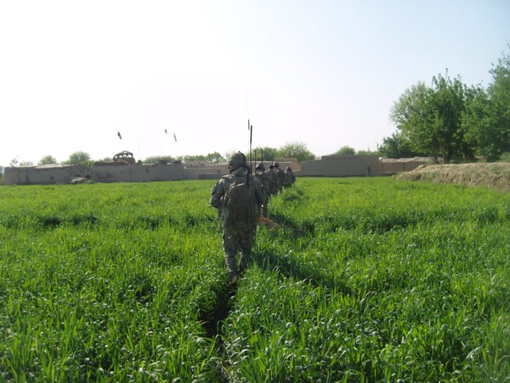 Crossing a field to reach a mud-walled compound.
