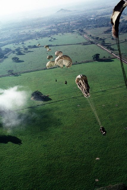 US Soldiers of 1st Battalion, 508th Infantry, parachute from a C-130E Hercules aircraft into a drop zone outside the city to conduct operations in support of Operation Just Cause.