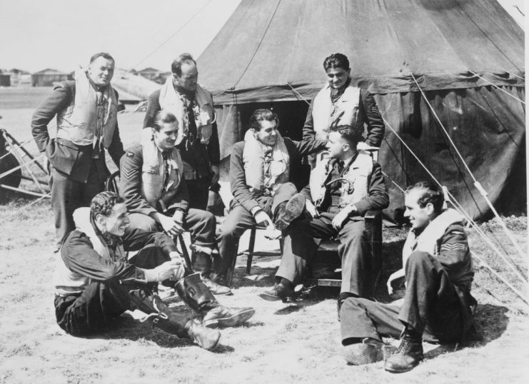 Left to right: Fighter pilots Stefan Witorzenc, George Stoney, Antoni Głowacki and sitting Bob Dafforn, Paul Farnes (1918 – 2020), Kenneth “Hawkeye” Lee, John Gibson and Hugh Adams of No 501 (County of Gloucester) Squadron Royal Auxiliary Air Force rest between sorties and listen to an account given by Gibson who has just bailed out of his aircraft, having been shot down by an enemy aircraft on 15th August 1940 at RAF Hawkinge, near Folkstone, Kent, England. Sgt Antoni Głowacki is also notable for shooting down five German aircraft on 24th August 1940 during the Battle of Britain, becoming one of only four pilots who gained “ace-in-a-day” status during that battle. (Photo by Central Press/Hulton Archive/Getty Images)