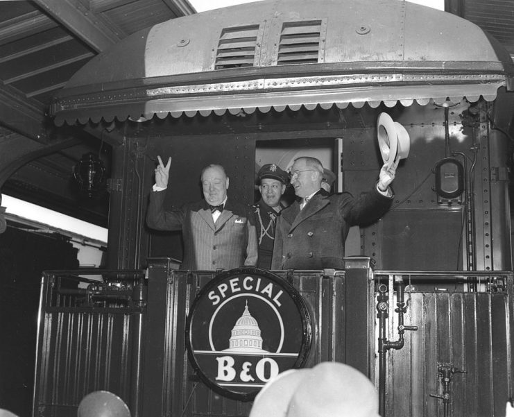 British Prime Minister Winston Churchill (1874 – 1965) gives a ‘V for Victory’ sign as he and US President Harry S. Truman (1884 – 1972) wave from the back of the President’s train in Union Station, Washington DC, March 4, 1946. White House Aide General Harry H. Vaughan (1893 – 1981) stands between them. (Photo by Abbie Rowe/PhotoQuest/Getty Images)