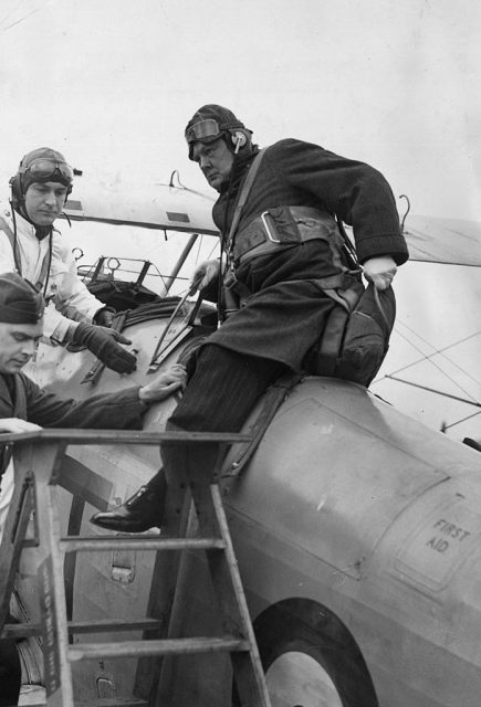 16th April 1939: British statesman Winston Churchill (right), recently appointed Hon Air Commodore to 615 Auxiliary Air Force Squadron, climbing out of a Gloster Gauntlet II aircraft during a visit to the Squadron at Kenley, Surrey. (Photo by Arthur Tanner/Fox Photos/Getty Images)