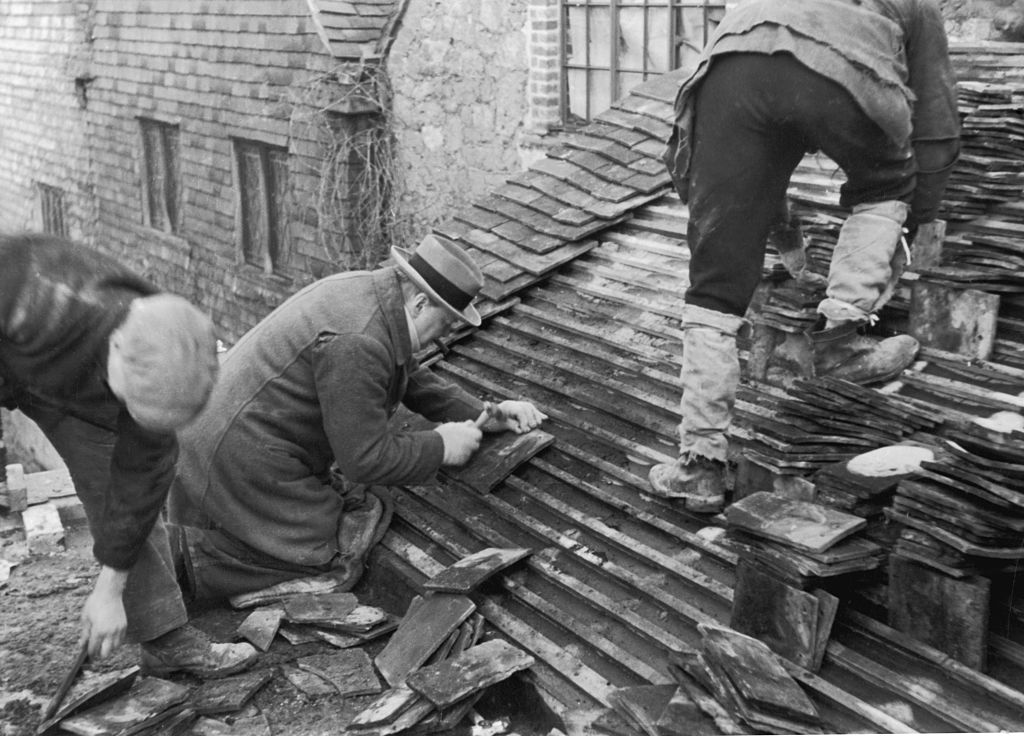 British statesman Winston Churchill (1874 - 1965) helping to lay tiles on the roof of a new cottage at his Chartwell estate in Kent, 25th February 1939. Original publication: Picture Post - 90 - Churchill - pub. 1939 (Photo by Picture Post/Hulton Archive/Getty Images)