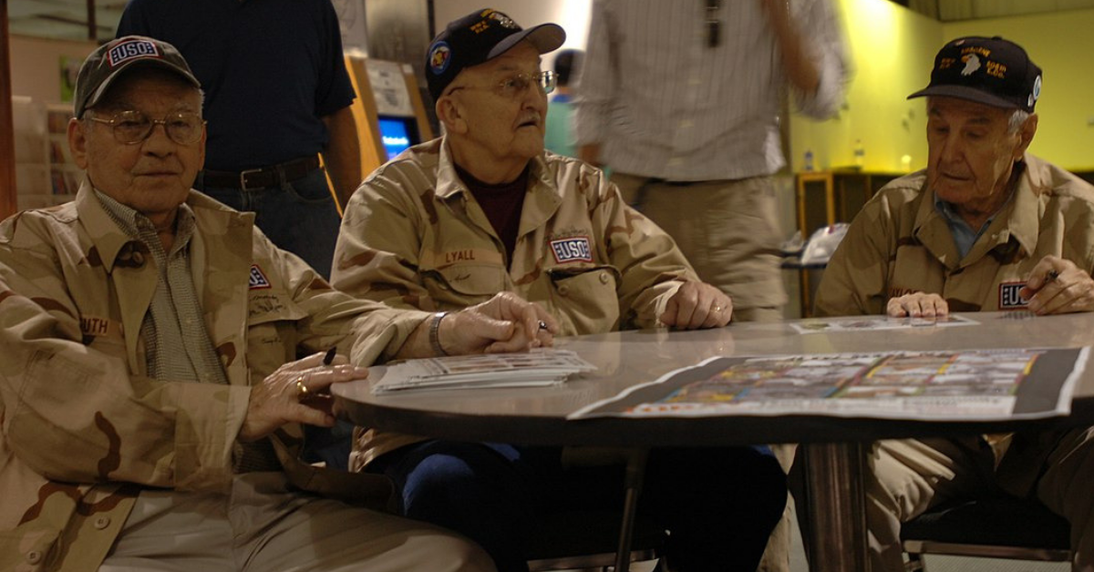 From left, Forrest Guth, Clancy Lyall and Amos “Buck” Taylor, WWII veterans and members of Easy Company as featured in the TV series “Band of Brothers,” pose for photos and sign autographs for troops during a week-long visit to the Middle East.