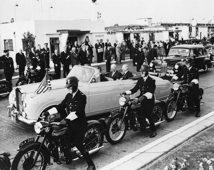 President Eisenhower and Prime Minister Harold Macmillan sitting in the back of a Rolls Royce, flanked by a convoy of police on motorcycles as they drive through London, August 27th 1959. (Photo by Fox Photos/Hulton Archive/Getty Images)