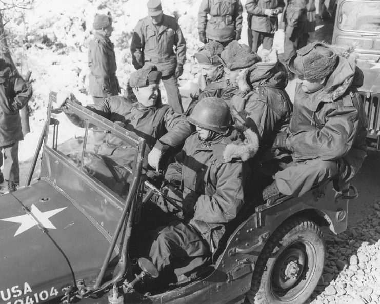 In a jeep, American former soldier and US President-elect Dwight D Eisenhower (1890 – 1969) (left, looking over his shoulder) talks with United Nations Commander in Chief General Mark W Clark (1896 – 1984) (back seat, center) and unidentified others during a tour of the 2nd US Infantry Division headquarters, Korea, December 5, 1952. (Photo by PhotoQuest/Getty Images)